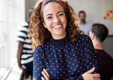 Smiling Woman with Curly Hair Crossing Arms and Smiling